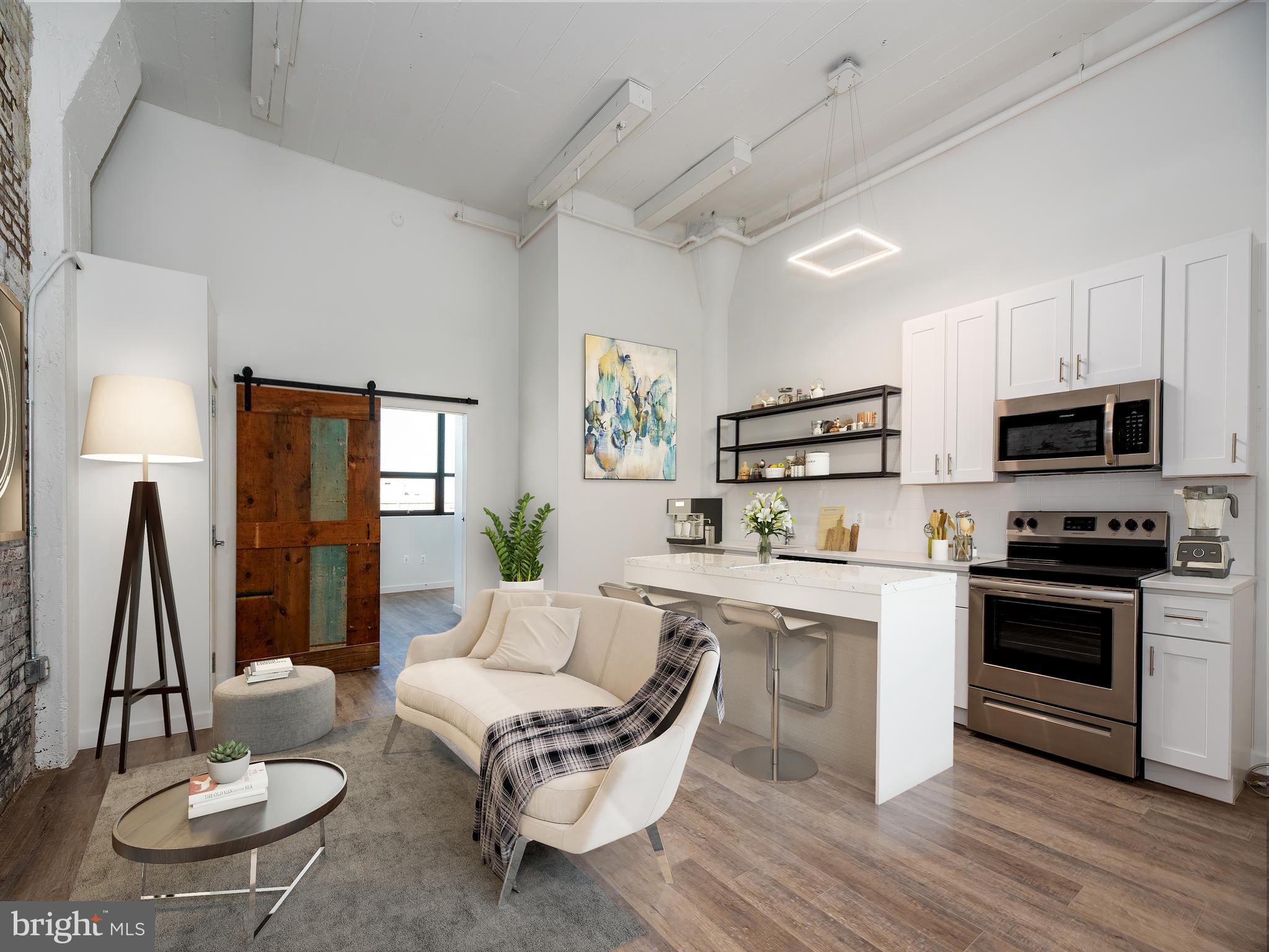 a living room with stainless steel appliances a dining table wooden floor and a fireplace