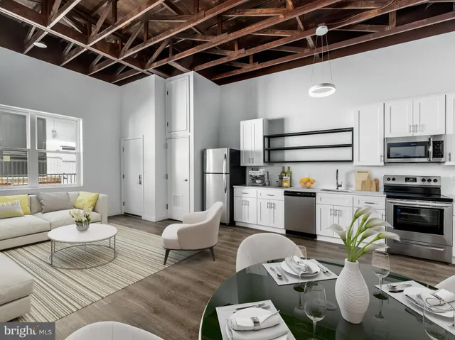 a living room with furniture kitchen view and a fireplace