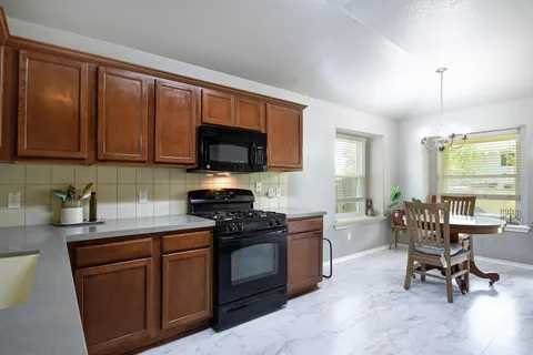a kitchen with stainless steel appliances a stove sink microwave and cabinets