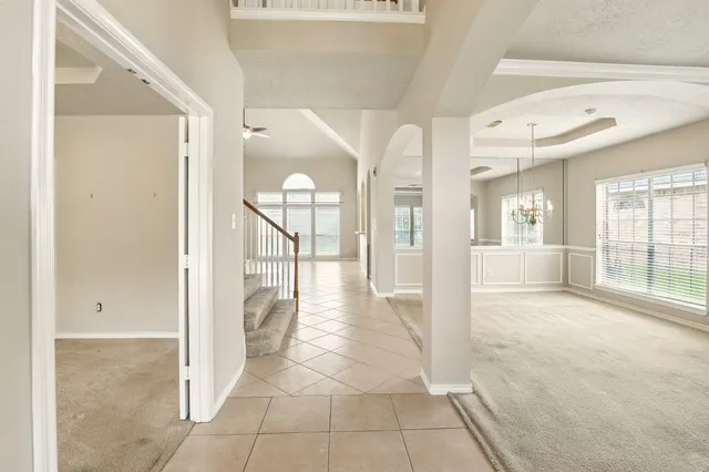 a view of a hallway with wooden floor and a living room