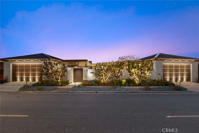 a view of a house with a small yard and potted plants