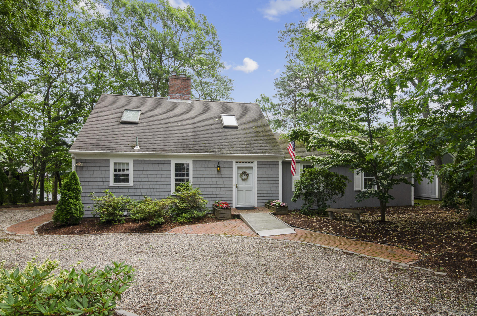 front view of house with a yard and potted plants
