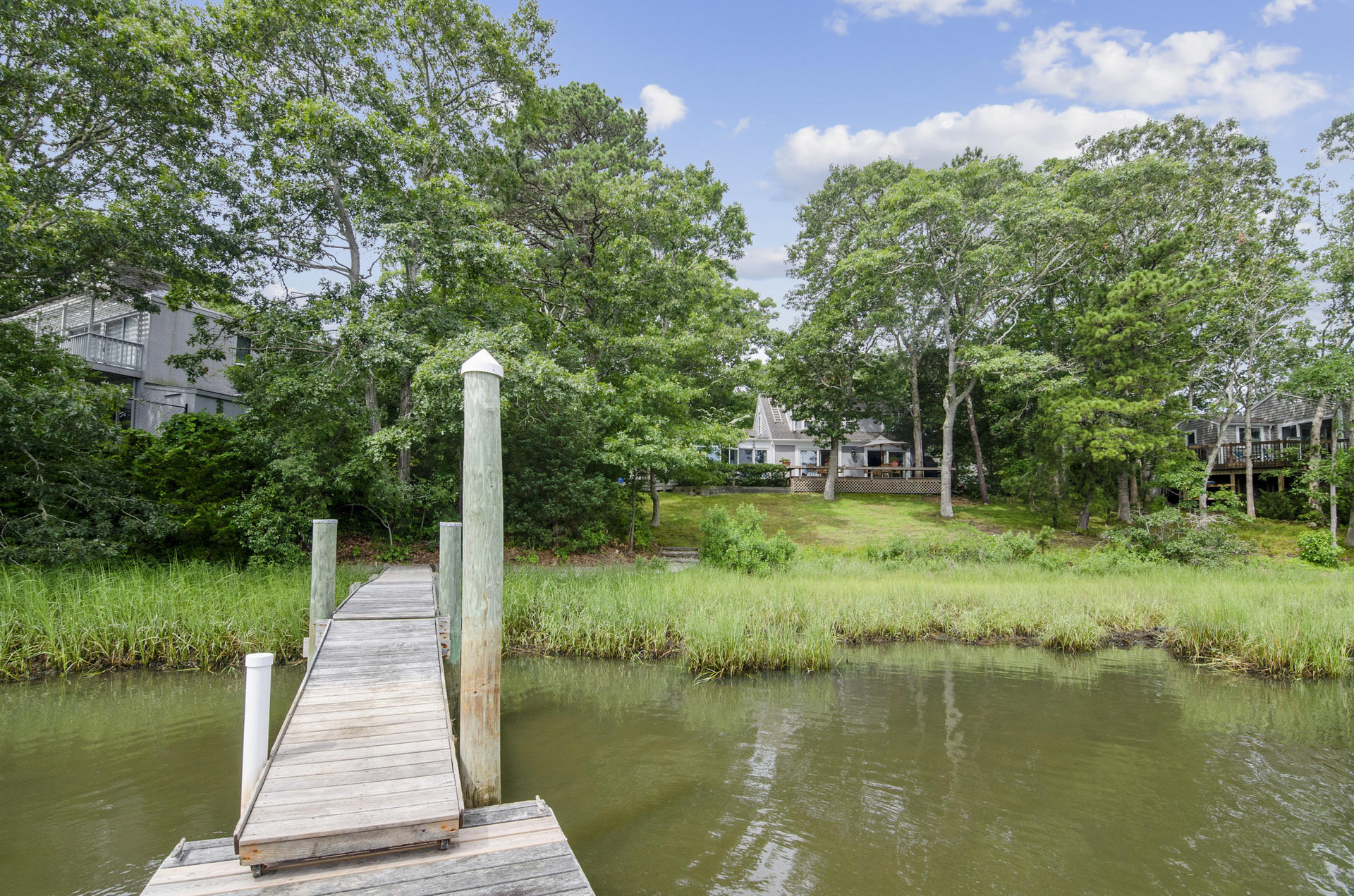 33 Fiddler Crab Lane Mashpee, MA 02649 - Photo 20 of 23 a view of a lake with a wooden bridge
