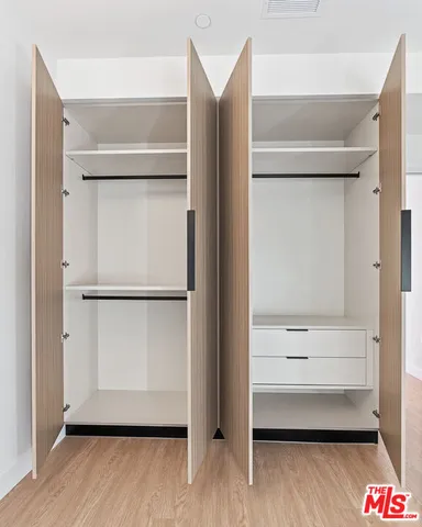 a view of walk in closet with empty racks