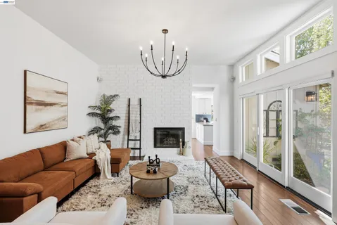 a living room with furniture a fireplace and a large window