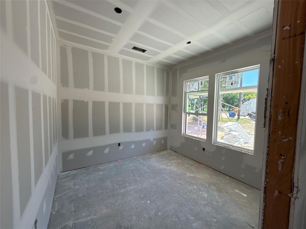 Room under construction featuring two large windows, a tray ceiling, and new drywall