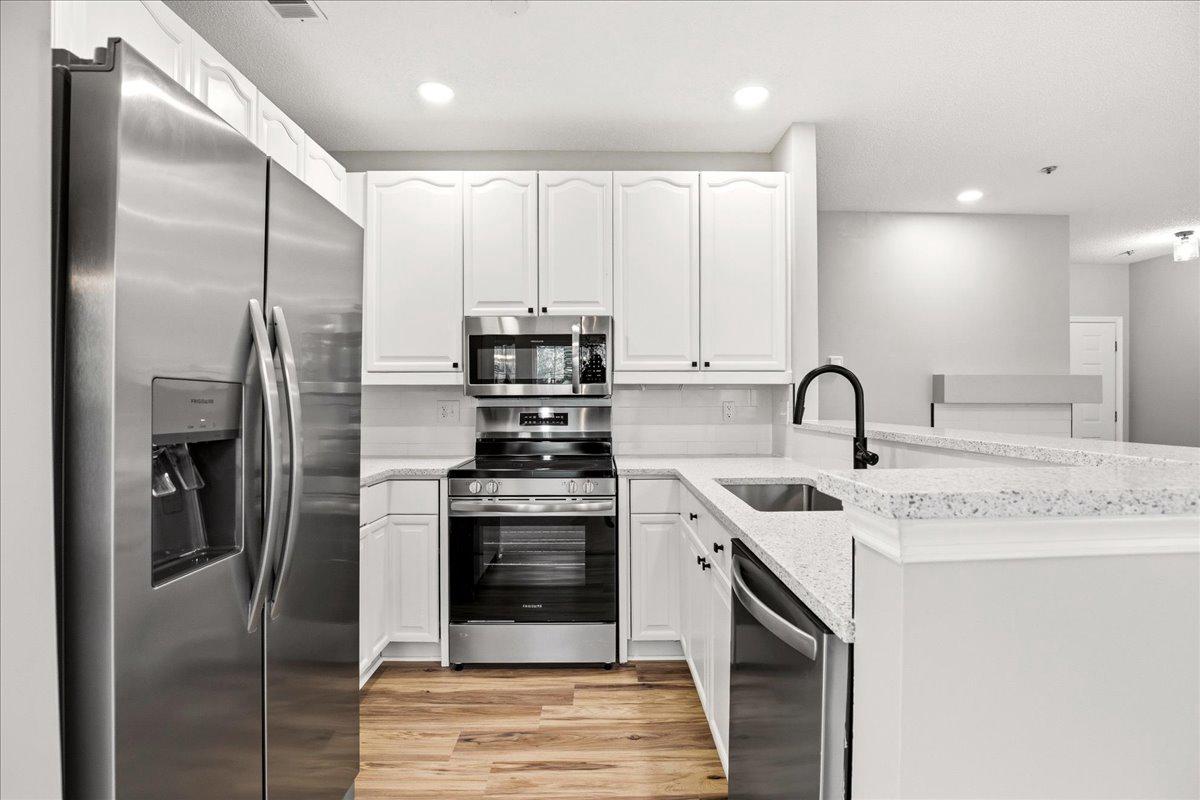 1223 Back Creek Loop, Unit 1223 Solomons, MD 20688 - Photo 16 of 44 a kitchen with stainless steel appliances granite countertop a sink a stove and a refrigerator