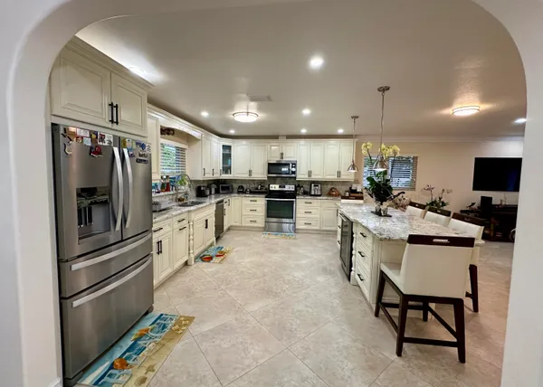 a kitchen with refrigerator and chairs