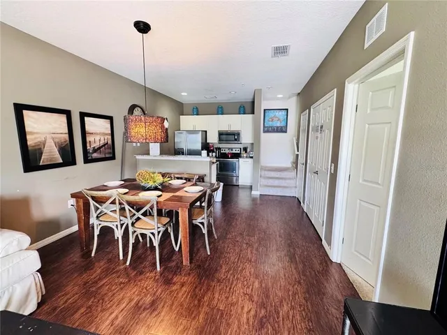 a view of a dining room with furniture a rug and wooden floor