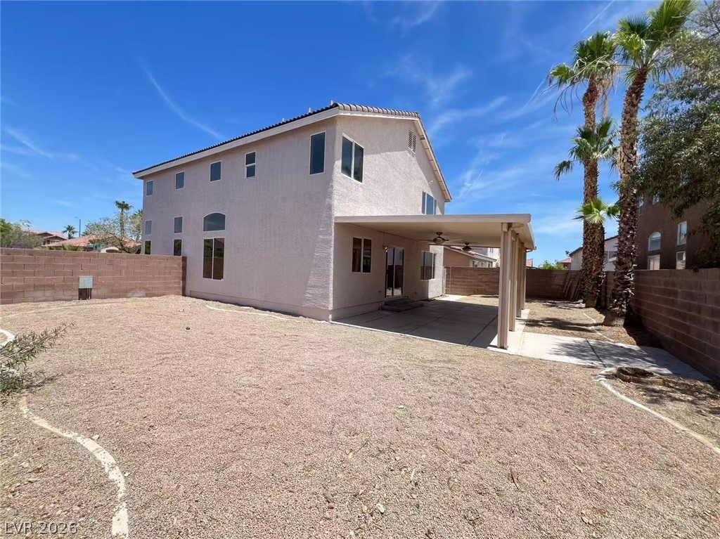 9891 Ridge Hill Avenue Las Vegas, NV 89147 - Photo 29 of 29 A spacious backyard with mature palm trees and a covered patio offers ample outdoor living potential.