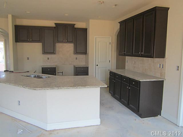 7018 Sedgewick Road, Unit AD100 Indian Trail, NC 28079 - Photo 2 of 3 a kitchen with granite countertop cabinets and black appliances