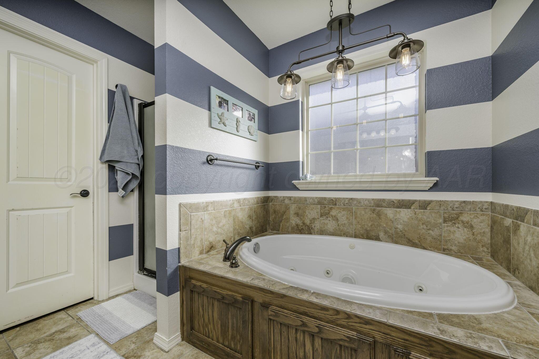 3504 Springfield Avenue Amarillo, TX 79118 - Photo 13 of 23 a white bath tub sitting next to a window