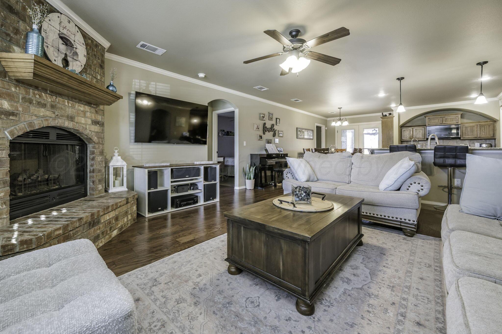 3504 Springfield Avenue Amarillo, TX 79118 - Photo 3 of 23 a living room with furniture a flat screen tv and a fireplace