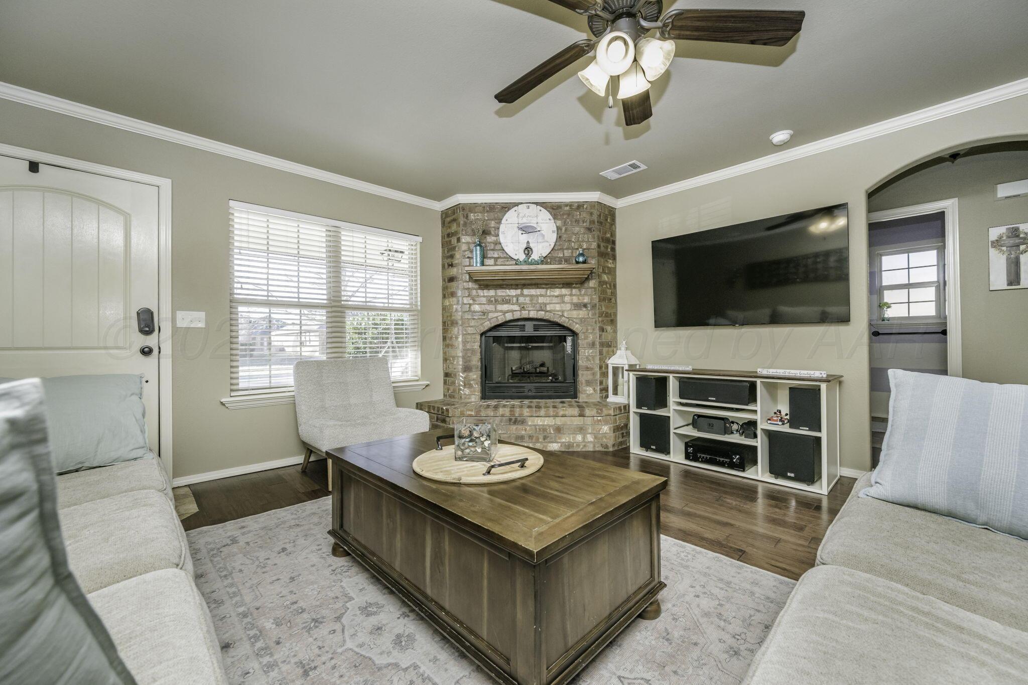 3504 Springfield Avenue Amarillo, TX 79118 - Photo 5 of 23 a living room with furniture a fireplace and a flat screen tv