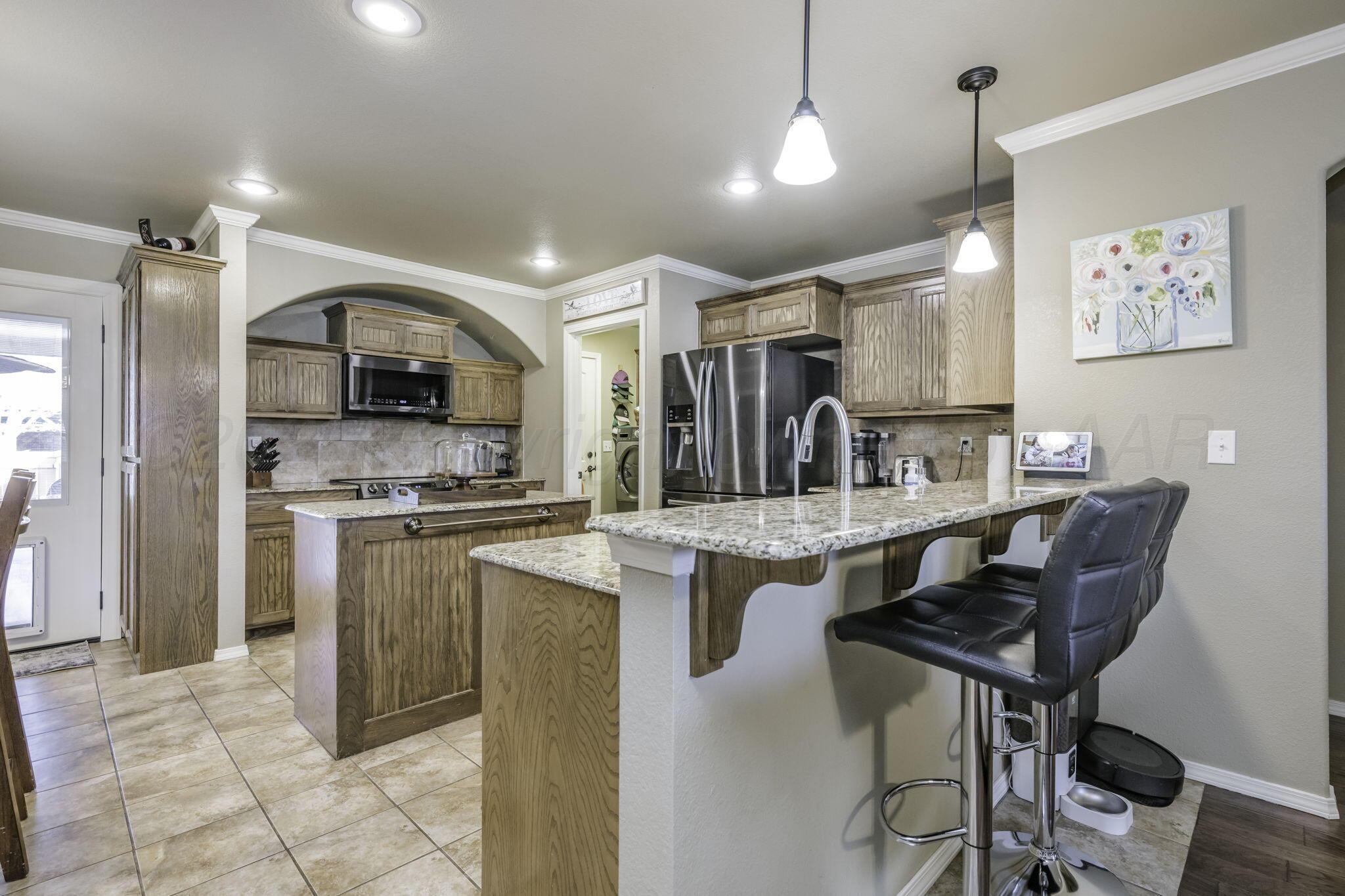 3504 Springfield Avenue Amarillo, TX 79118 - Photo 7 of 23 a kitchen with granite countertop a sink cabinets and stainless steel appliances