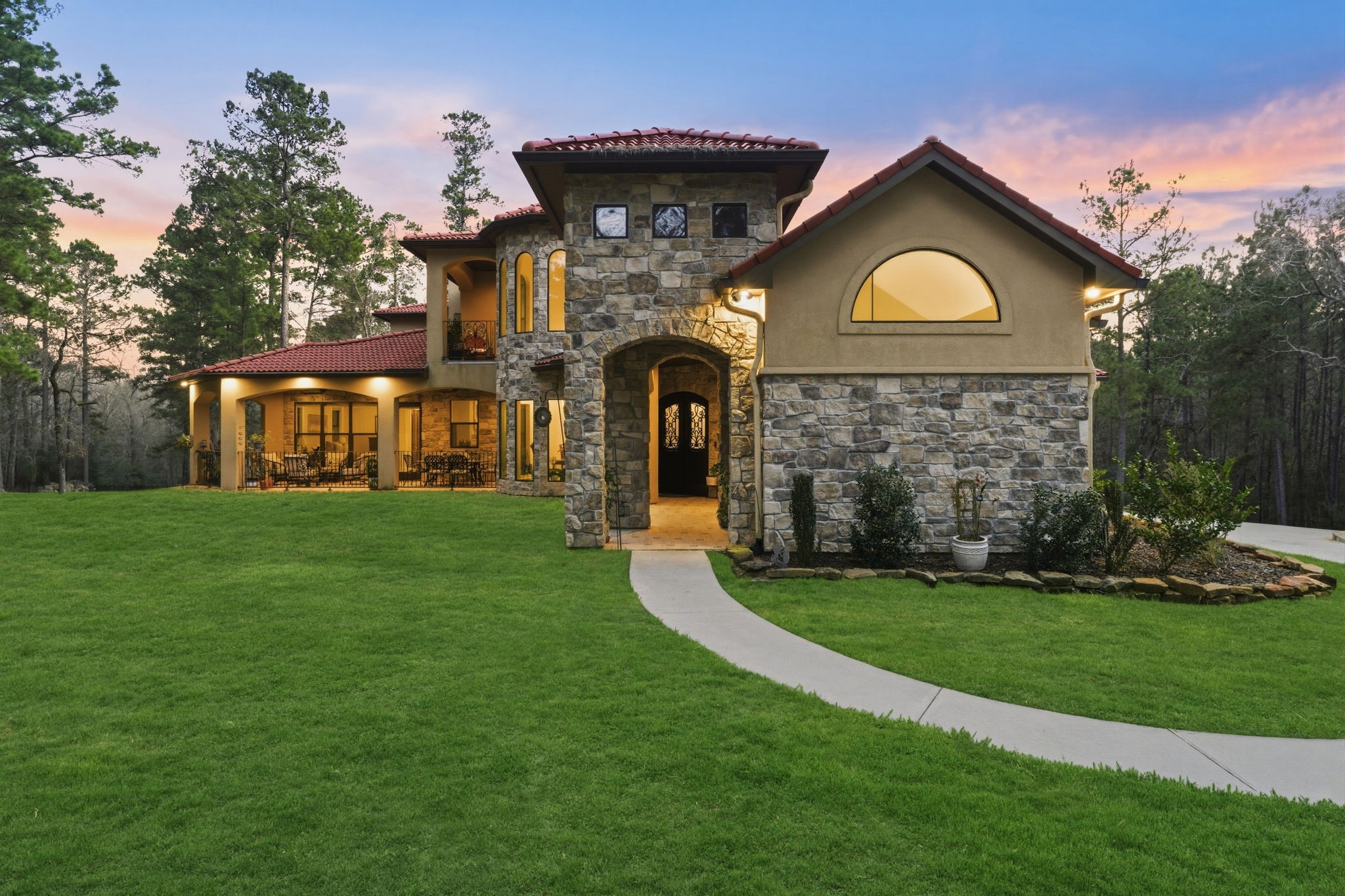 280 Sundog Road Huntsville, TX 77340 - Photo 3 of 50 Beautiful stone and stucco exterior, tile roof, and inviting front loggia — an ideal spot to relax and enjoy views of the expansive front grounds.