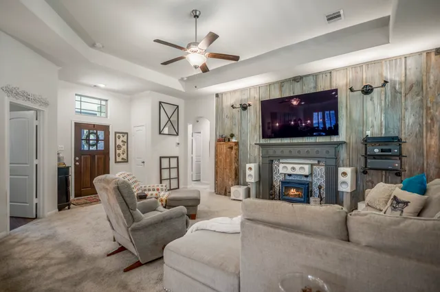 a living room with furniture a fireplace and a flat screen tv