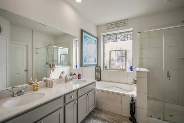 a bathroom with double vanity and a bathtub