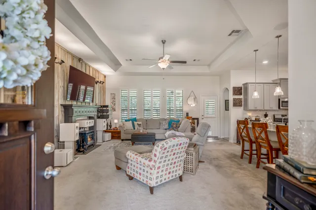 a living room with furniture ceiling fan and a large window
