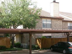 5626 Preston Oaks Road, Unit 39C Dallas, TX 75254 - Photo 21 of 38 Rear view of property featuring a chimney, covered parking, and stone siding