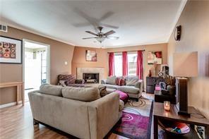 5626 Preston Oaks Road, Unit 39C Dallas, TX 75254 - Photo 25 of 38 Living area featuring a ceiling fan, wood finished floors, and a fireplace