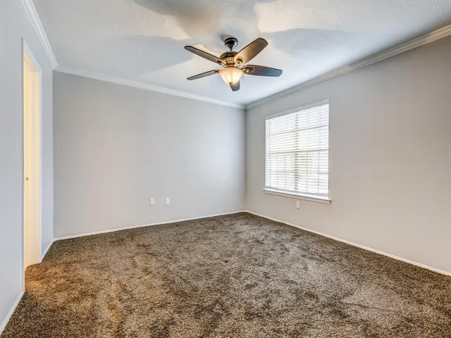 an empty room with window and ceiling fan