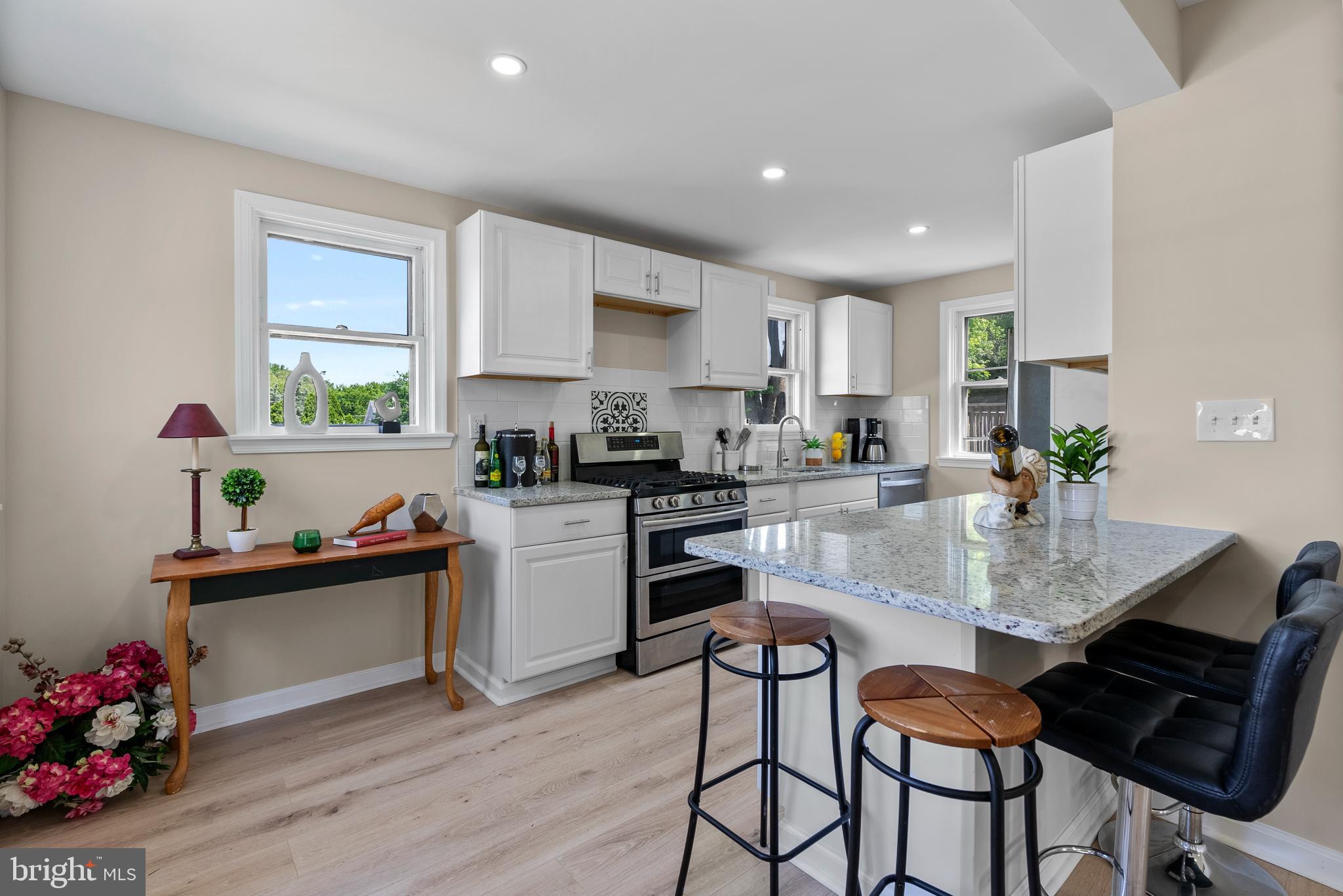 8020 Old Philadelphia Road Baltimore, MD 21237 - Photo 11 of 37 a kitchen with granite countertop a dining table cabinets appliances and wooden floor