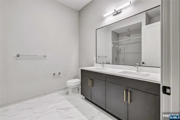 a bathroom with a double vanity sink toilet and a mirror