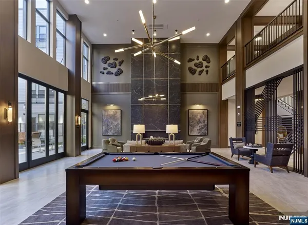 a living room with a table a chandelier and couches with wooden floor