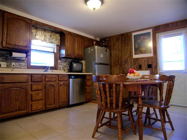 64 Bertwell Road Lexington, MA 02420 - Photo 5 of 18 a kitchen with granite countertop a dining table chairs and white cabinets