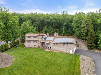 a aerial view of a house with pool garden and outdoor seating