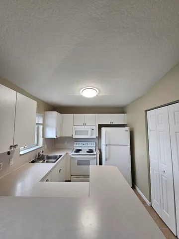 a kitchen with cabinets appliances a sink and a window