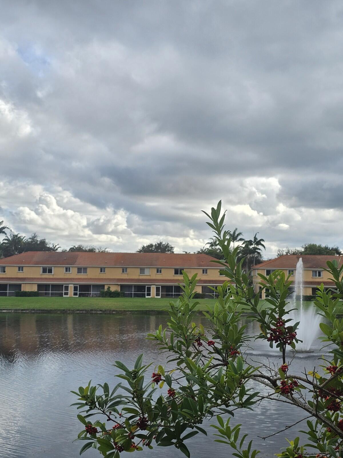 3490 Briar Bay Boulevard, Unit 206 West Palm Beach, FL 33411 - Photo 16 of 25 a view of a lake with a house in the background
