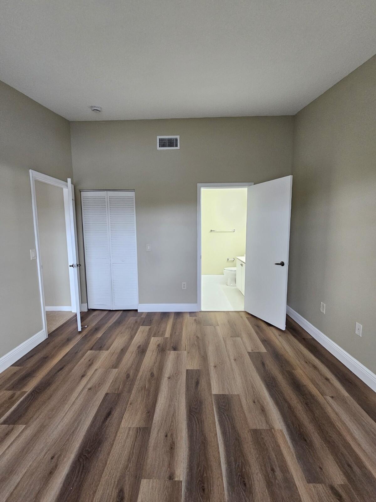 3490 Briar Bay Boulevard, Unit 206 West Palm Beach, FL 33411 - Photo 19 of 25 a view of an empty room and wooden floor