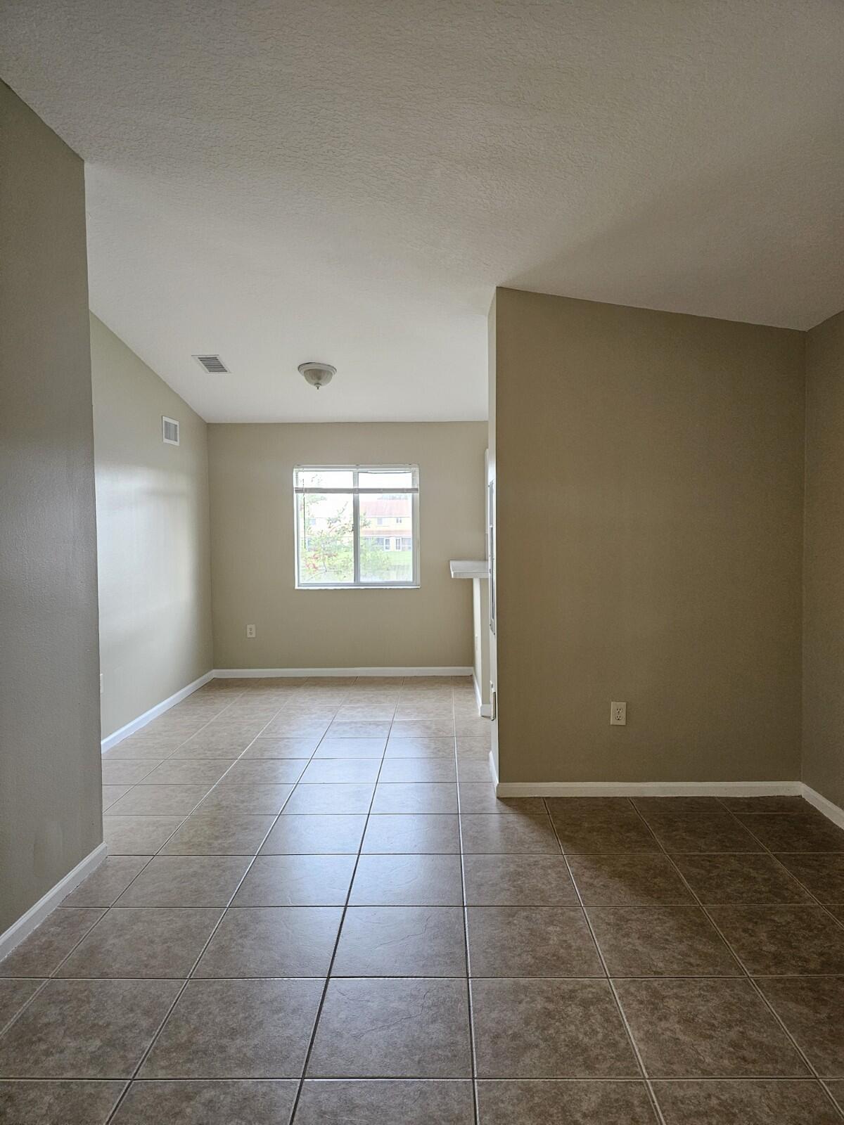3490 Briar Bay Boulevard, Unit 206 West Palm Beach, FL 33411 - Photo 2 of 25 a view of an empty room with a window