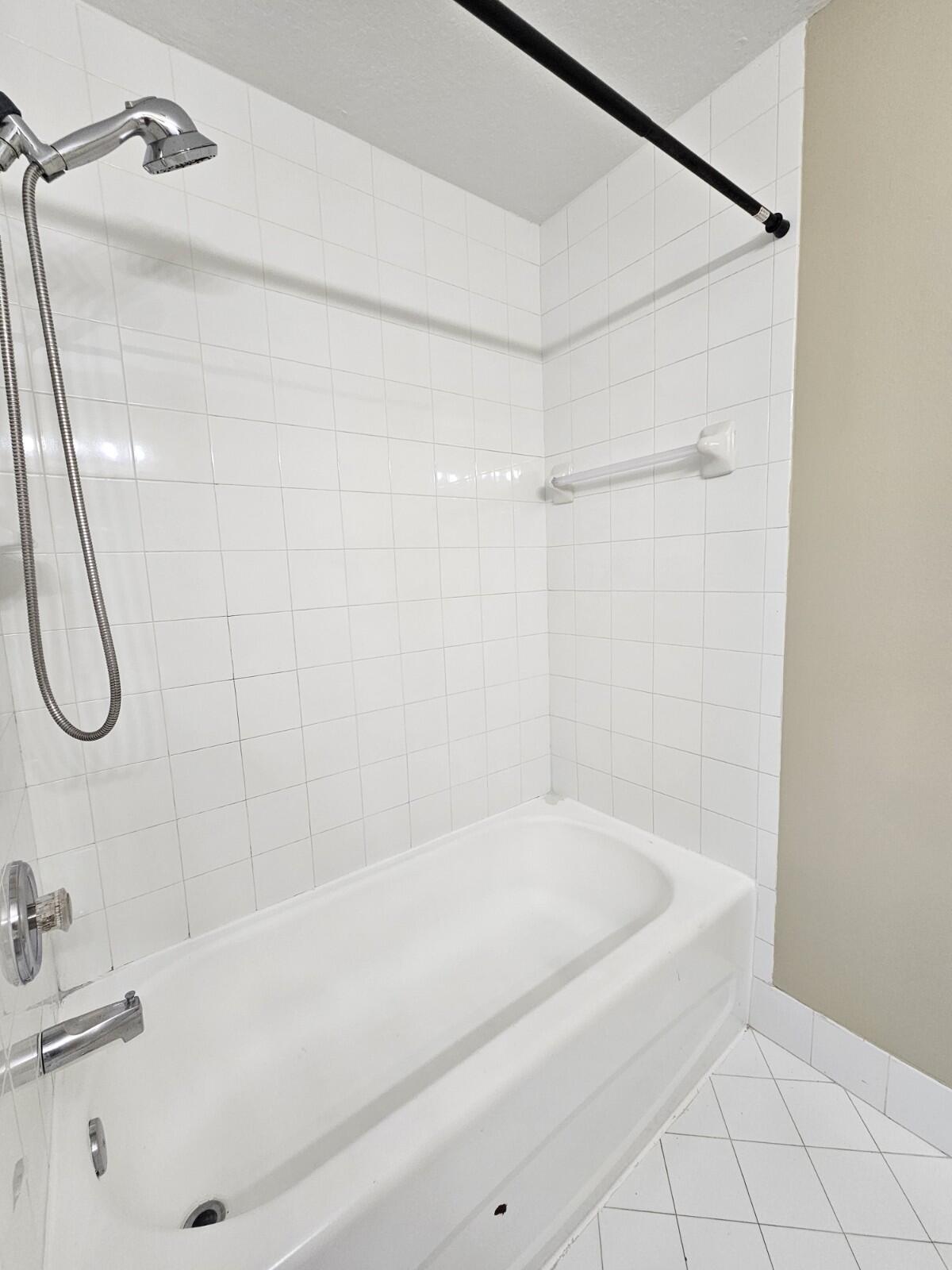 3490 Briar Bay Boulevard, Unit 206 West Palm Beach, FL 33411 - Photo 22 of 25 a bathroom with a bathtub and a shower