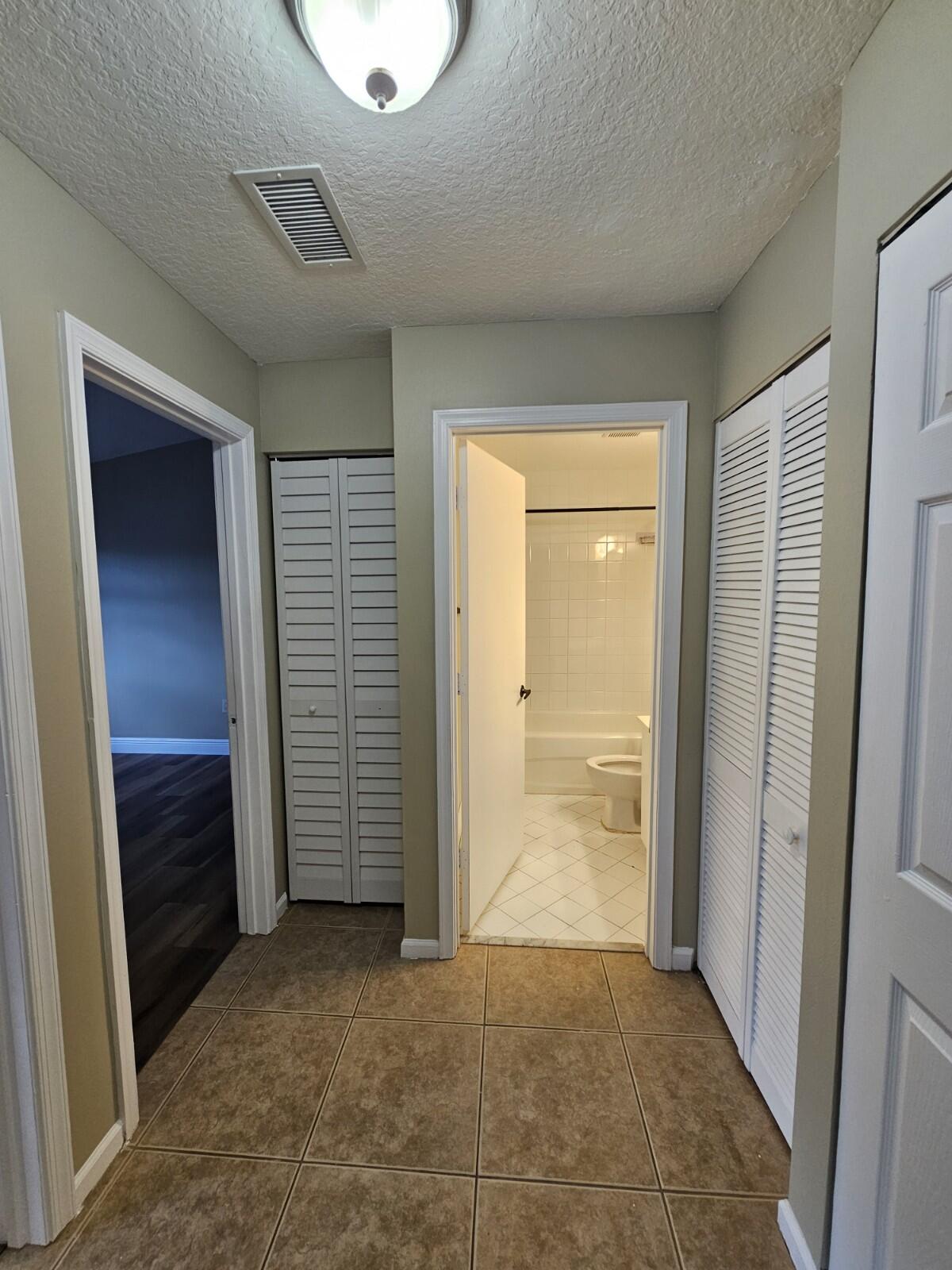 3490 Briar Bay Boulevard, Unit 206 West Palm Beach, FL 33411 - Photo 5 of 25 an empty room with closet and a bathroom