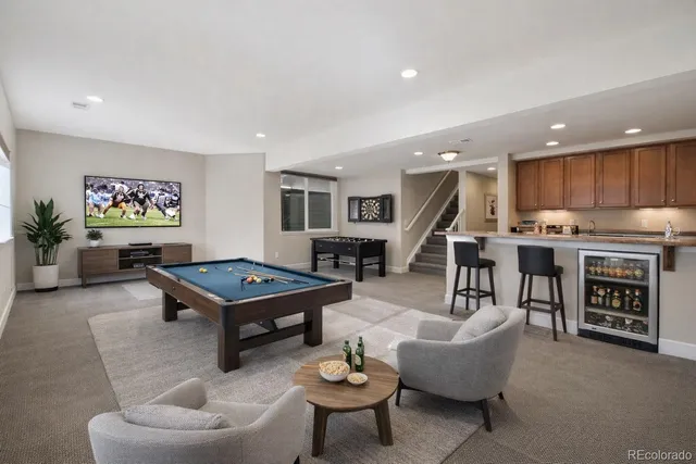 a living room with furniture a table and kitchen view