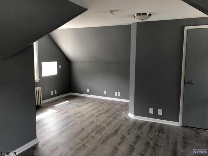 166 Carmita Avenue Rutherford, NJ 07070 - Photo 22 of 27 an empty room with wooden floor and windows