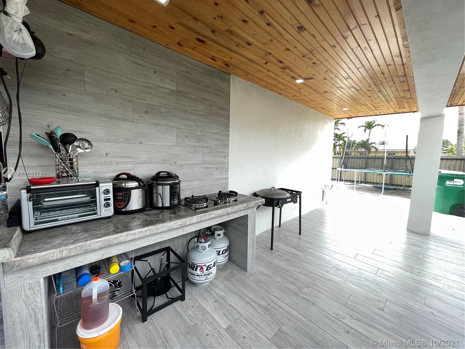 3541 Southwest 105th Court Miami, FL 33165 - Photo 38 of 45 a kitchen with stainless steel appliances granite countertop a sink a stove and wooden floors