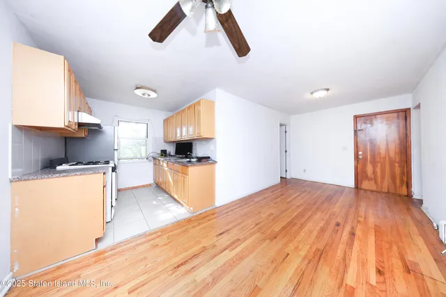 a kitchen with granite countertop wooden floors a stove and a sink