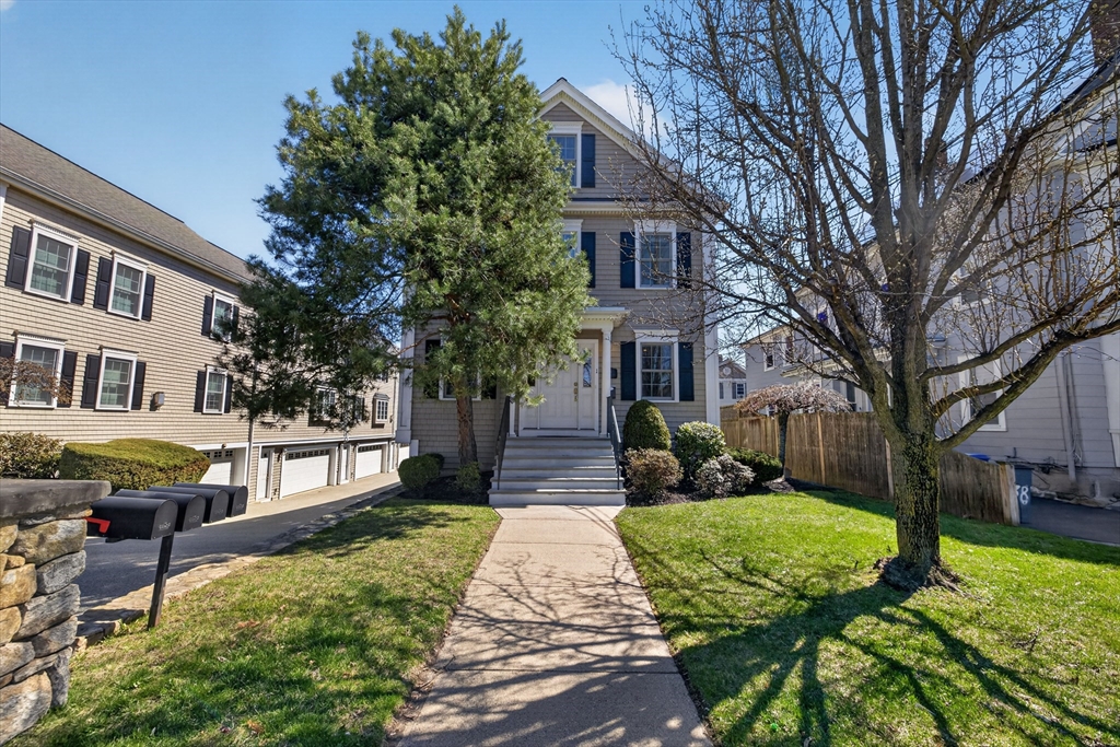 a front view of a house with a yard and potted plants