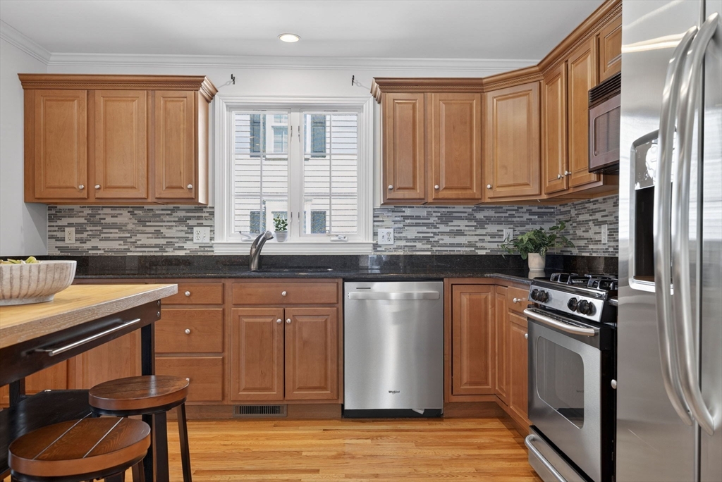 36 Prospect Street, Unit 1 Waltham, MA 02453 - Photo 5 of 16 a kitchen with stainless steel appliances granite countertop a stove a sink dishwasher a microwave oven with granite countertops and cabinets