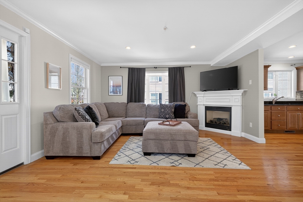36 Prospect Street, Unit 1 Waltham, MA 02453 - Photo 7 of 16 a living room with furniture a flat screen tv and a fireplace