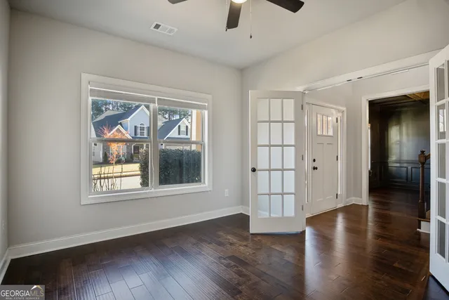 an empty room with windows and fan