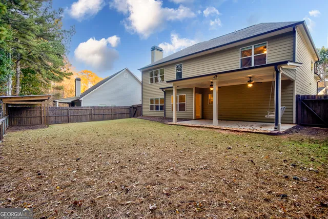 an empty room with windows fireplace and a chandelier fan