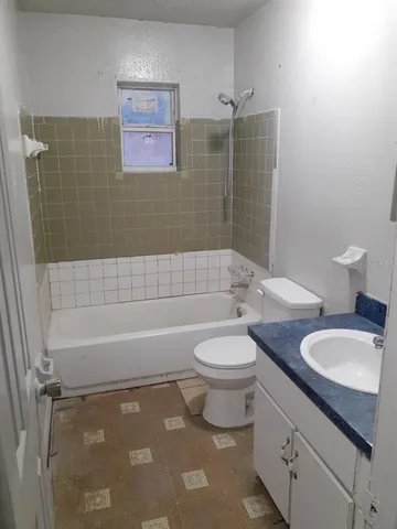 a bathroom with a granite countertop toilet a sink and bathtub