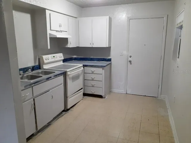 a kitchen with white cabinets and white appliances