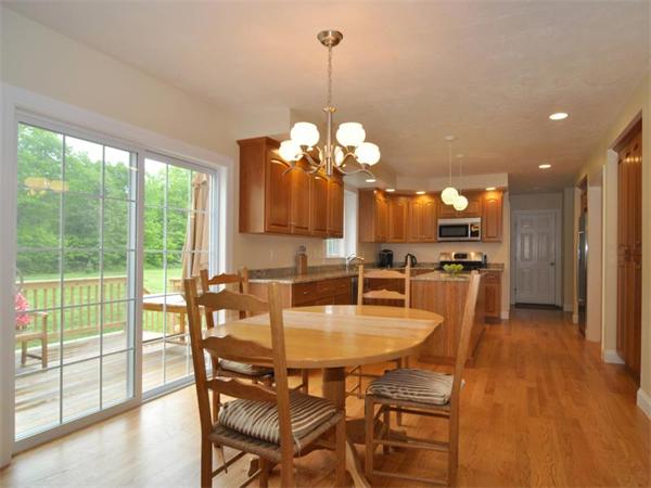 14 Hatch Road Wrentham, MA 02093 - Photo 9 of 28 a dining room with wooden floor a chandelier a wooden table and chairs
