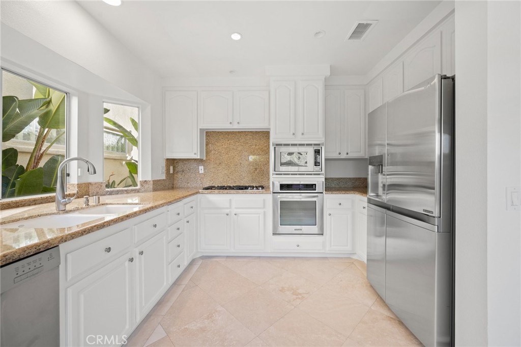 17 St John Dana Point, CA 92629 - Photo 3 of 30 a kitchen with granite countertop white cabinets and stainless steel appliances